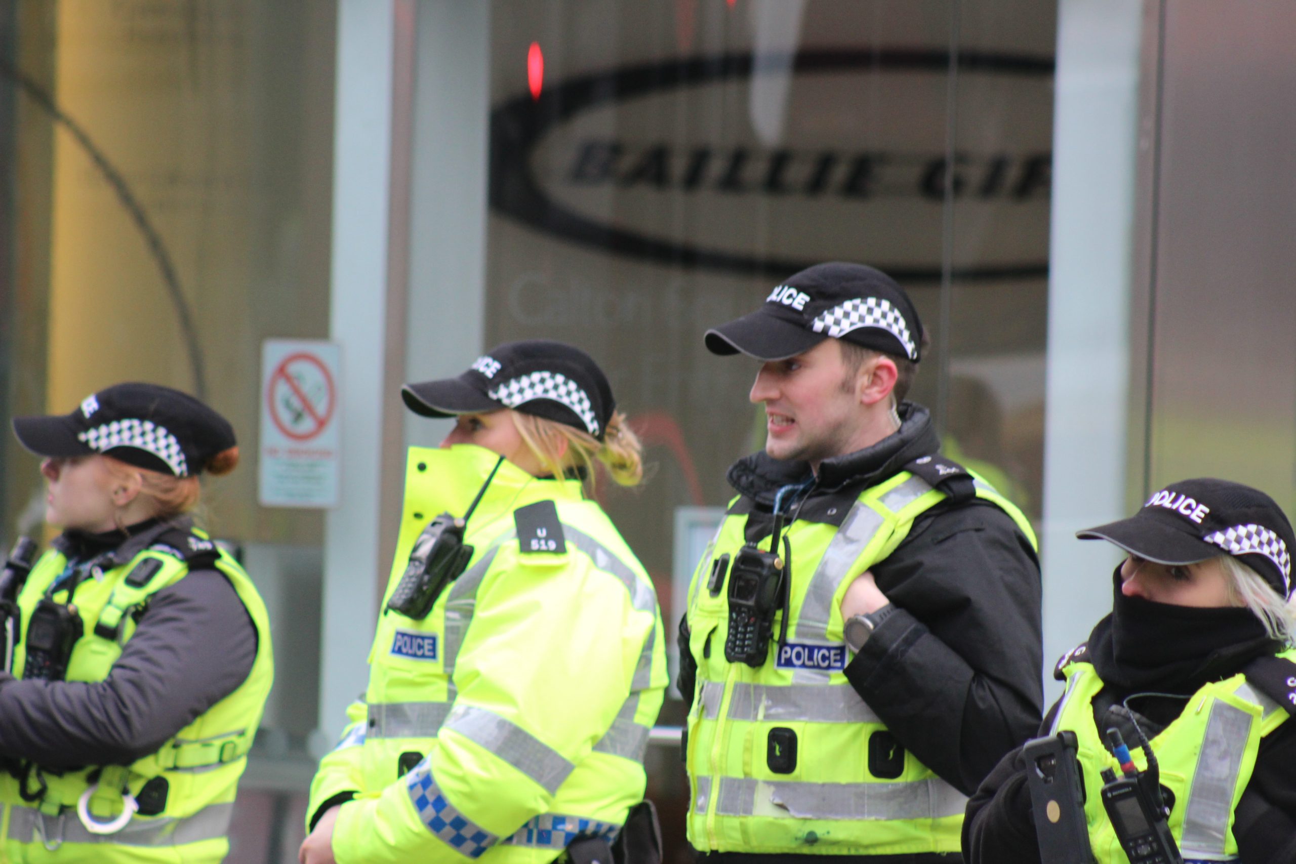 Police stand in a line outside Baillie Gifford
